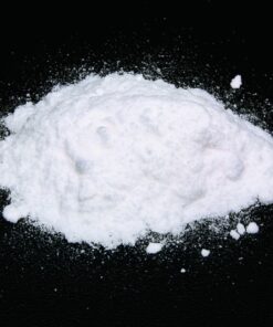 Close-up image of fine ketamine powder in a container, showcasing its smooth texture and high purity.